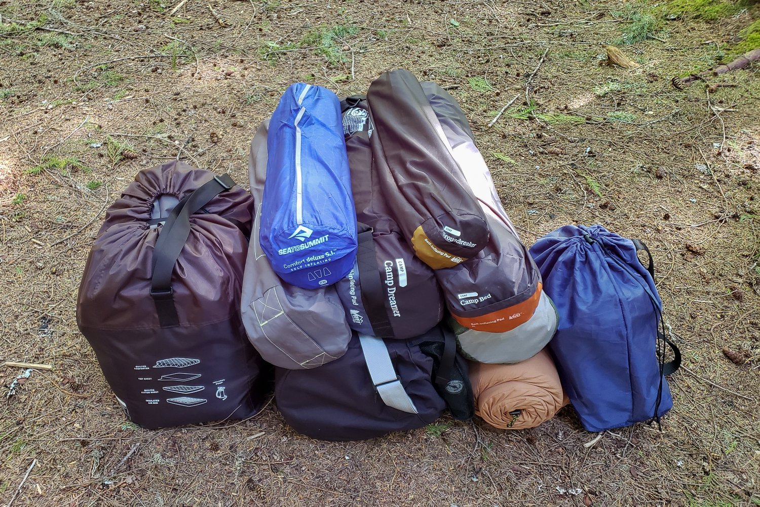 A pile of camping pads in their stuff sacks